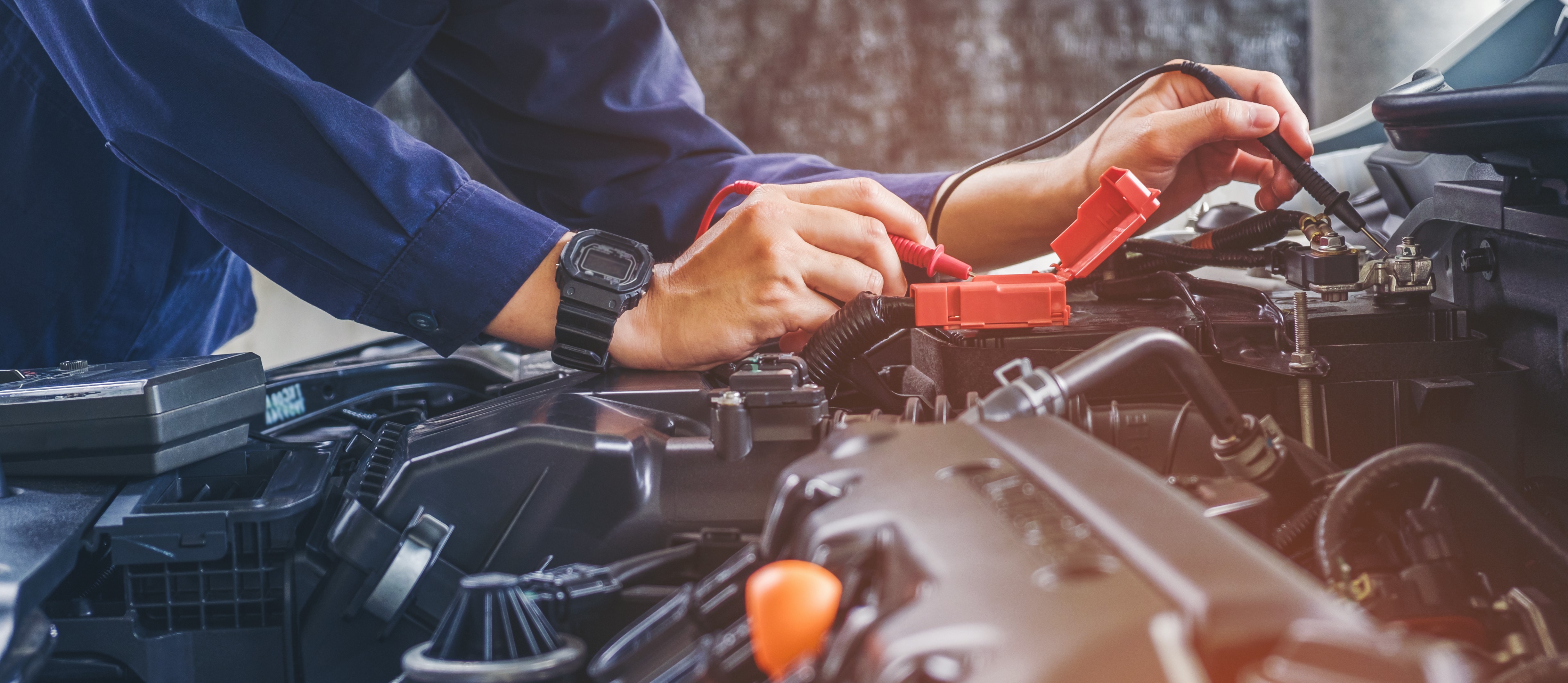 Mechanic performing Auto Repair services under the hood of a car